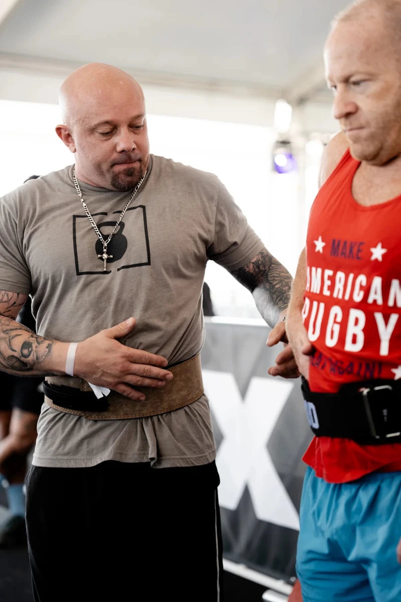 Coach helping athlete with a weightlifting belt